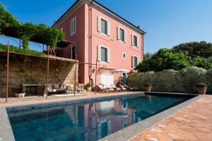 a house with a swimming pool next to a building at Villa Angelica in Peccioli