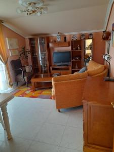 a living room with a couch and a tv at Atico augaboa in Cangas de Morrazo