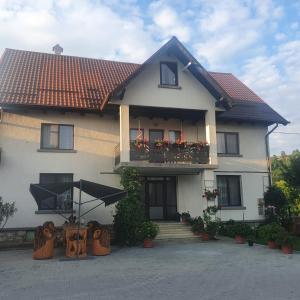 a large white house with a balcony with flowers at Casa Cornelia in Bran