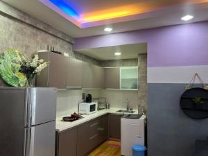 a kitchen with a refrigerator and a purple ceiling at Regalia suites 424 in Kuala Lumpur