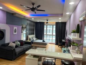uma sala de estar com um sofá e uma ventoinha de tecto em Regalia suites 424 em Kuala Lumpur