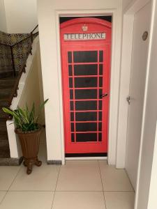 a red phone booth in a hallway with a staircase at Pousada Lorde Inglês in Recife