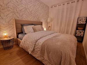 a bedroom with a bed with a white comforter at Les Alliés in Mulhouse