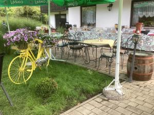 una bicicletta gialla parcheggiata accanto a un tavolo e sedie di Apartments & Rooms Preseren a Bled