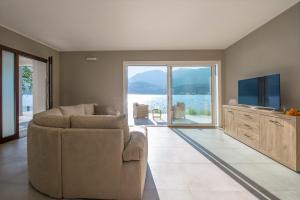 a living room with a couch and a flat screen tv at d'Ocalée Holiday Experience lago d'Orta in Omegna