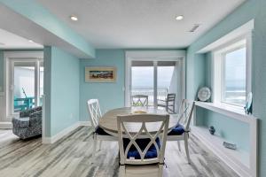 a dining room with blue walls and a table and chairs at JY422 - John Yancey Oceanfront Inn Penthouse Suite in Kill Devil Hills