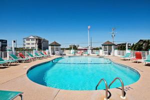 a large swimming pool with chairs at JY422 - John Yancey Oceanfront Inn Penthouse Suite in Kill Devil Hills