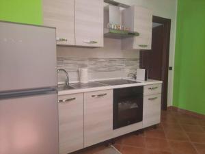 een keuken met witte kasten, een wastafel en een koelkast bij GROSSI 19 in Rho