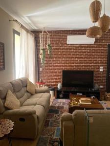a living room with a couch and a brick wall at luxurious 2bed's duplex sheikh zayed beverly hills in Sheikh Zayed