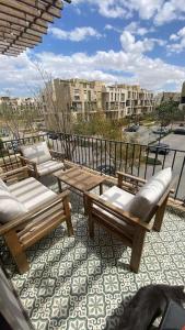 two chairs and a table on a balcony with a view at luxurious 2bed's duplex sheikh zayed beverly hills in Sheikh Zayed