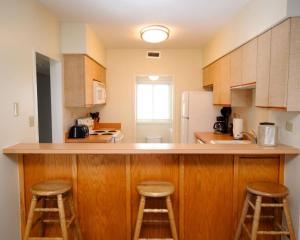 a kitchen with a counter and three stools in it at SR-T1-Room Type K,2T,QSS in Kill Devil Hills