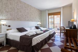 ein Hotelzimmer mit einem großen Bett und einem Schreibtisch in der Unterkunft Hotel Avenida Tropical by Bossh! Hotels in Salobreña