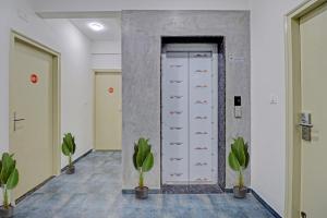 a hallway with a row of drawers and potted plants at Capital O Royal Manyata in Bangalore