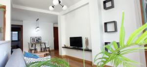 sala de estar con sofá y TV en la pared en Apartamento en Moaña, en Moaña
