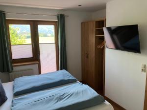 a bedroom with a bed and a flat screen tv at Ramseiderhof in Saalfelden am Steinernen Meer