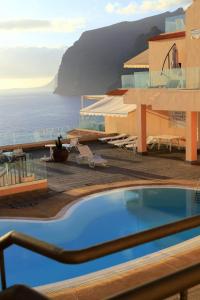 a hotel with a swimming pool and a view of the ocean at Buenavista in Acantilado de los Gigantes