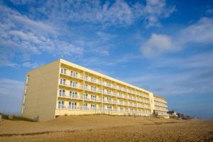 a large building on the beach next to the sand at SR-K1 - Room Type K,K,QSS in Kill Devil Hills