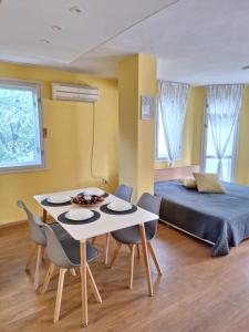 Habitación con cama, mesa y sillas. en Top Location Harmony Apartment by HostEx, en Varna