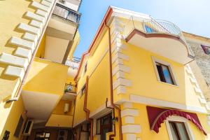 un edificio amarillo con balcón en una calle en Hotel La Marina, en Santa Maria di Castellabate