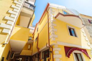 un edificio giallo con balcone su una strada di Hotel La Marina a Santa Maria di Castellabate