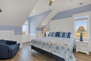 a blue bedroom with a bed and a blue chair at Sunrises to Sunsets in Nags Head
