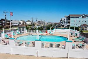 a view of a pool with chairs and a swimming pool at CR201 Salty Tides in Kill Devil Hills