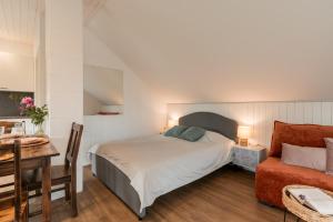 - une chambre avec un lit, une table et un canapé dans l'établissement Lapmanni Studios, à Haapsalu