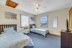 a bedroom with two beds and a ceiling fan at 1904 - The Yancey Cottage MP 9,5 in Kill Devil Hills +50 photos