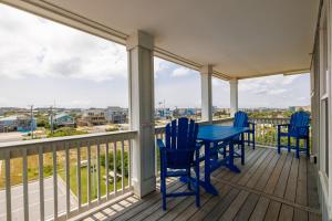 un porche avec des chaises bleues et une table avec vue dans l'établissement SC301 Langman's Sea Cabin, à Kill Devil Hills