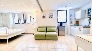 sala de estar con silla verde y cocina en Studio am Waldbach en Gernsbach