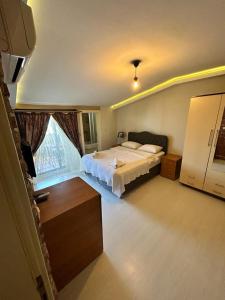 a bedroom with a bed and a large window at Hypatia Apt in Trabzon
