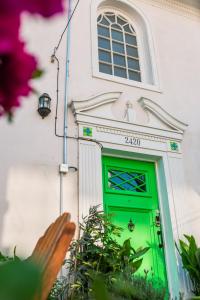 a green door in a white building with a window at Yogi Hostel in Santiago