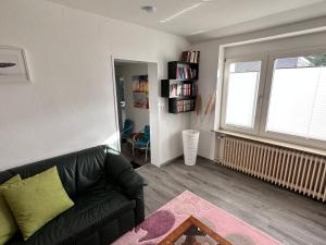 a living room with a black couch and a window at Nordsee Wohlfühloase in Norden +1 photo