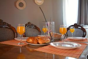 una mesa con un plato de pan y vasos de zumo de naranja en Afroditi first floor apartment, en Achílleion