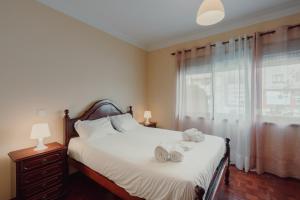 1 dormitorio con 1 cama con toallas en Rising Sun Apartment en Leça da Palmeira