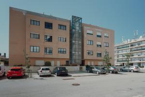 een groot gebouw met auto's geparkeerd op een parkeerplaats bij Rising Sun Apartment by Best2Stay in Leça da Palmeira