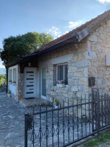 uma casa de pedra com uma cerca em frente em Kuca za iznajmljivanje ANDRIJA em Ljubuski