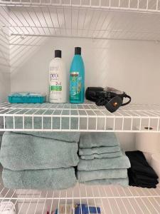 two bottles of soap and towels on a shelf in a refrigerator at Hartford Downtown: 2mins walk to XL Center in Hartford
