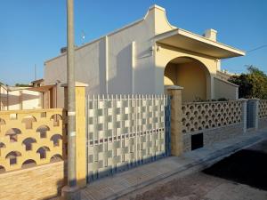 a house with a fence and a gate at Casa Vacanze da Lui' in Torre Lapillo