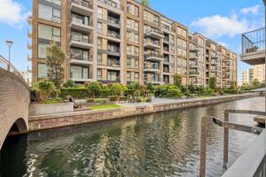 a river in front of a building with a canal at Canal Side Luxury 1 Bed Chelsea in London
