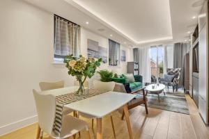 uma sala de estar com mesa e cadeiras em Canal Side Luxury 1 Bed Chelsea em Londres