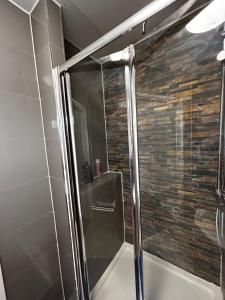 a shower with a glass door in a bathroom at The Ruislip Apartment in Ruislip