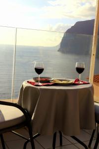 a table with two glasses of red wine on it at Buenavista in Acantilado de los Gigantes