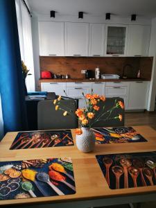 eine Küche mit einem Tisch und einer Blumenvase darauf in der Unterkunft Under the Hill 2 in Bad Muskau