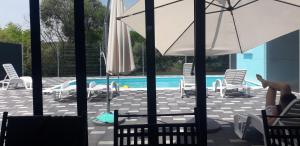 a pool with chairs and umbrellas and a person sitting in avisoragement at "DreamHome Mušić" Gomjenica in Gomjenica