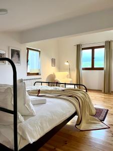 a bedroom with a large bed with white sheets at Divine House in Žabljak