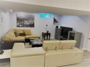 ein Wohnzimmer mit 2 Sofas und einem TV in der Unterkunft Gilford Beach Apartment in Innisfil