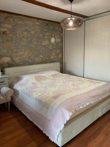 een slaapkamer met een bed en een stenen muur bij Kuca za iznajmljivanje ANDRIJA in Ljubuški