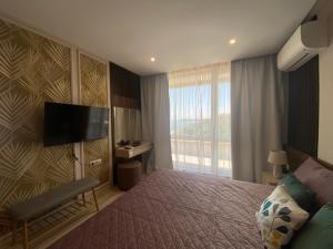 a hotel room with a bed and a television at PARADISO 607 Large Luxury Apartment in Nesebar