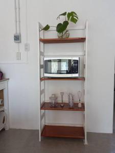 a shelf with a microwave on top of it at Departamento impecable. con cochera in Luján